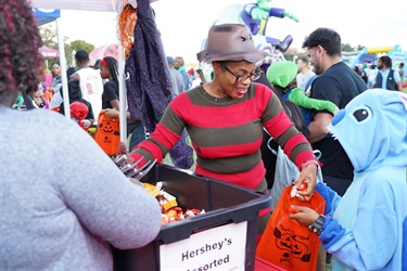Commissioner-Cherasard-giving-away-candy-at-2025-Halloween-event