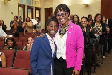 Commissioner Cherasard with Young Boy in the Commissioner Chambers
